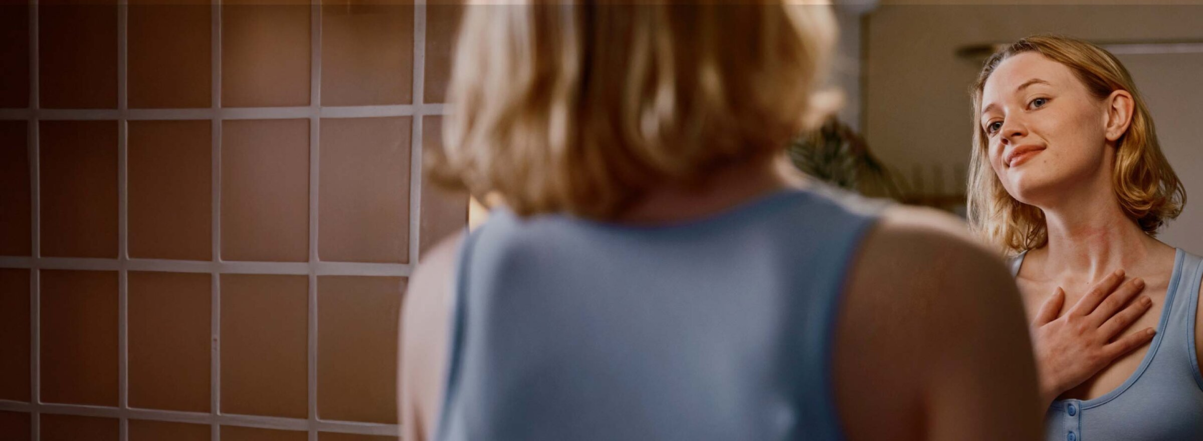 Woman looking in bathroom mirror