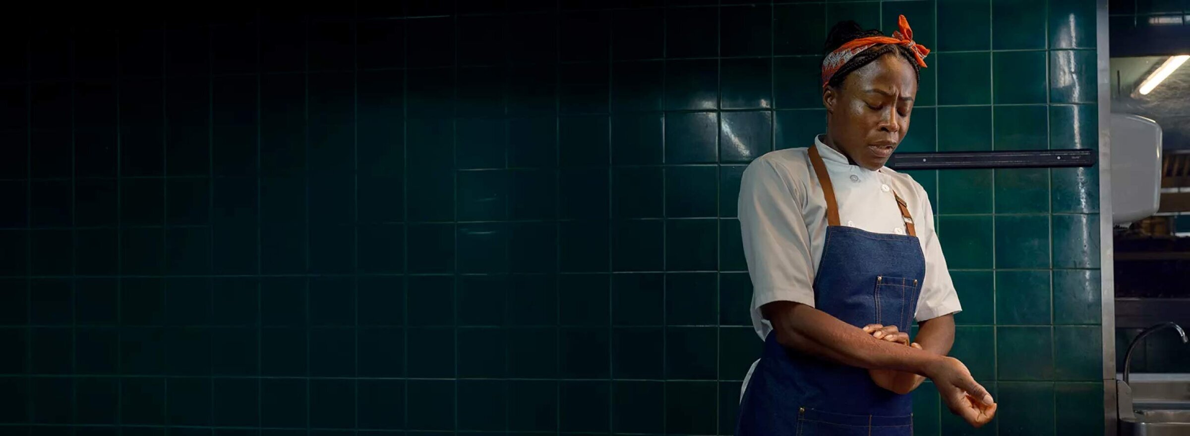 Woman at work looking at her hives on her arm.